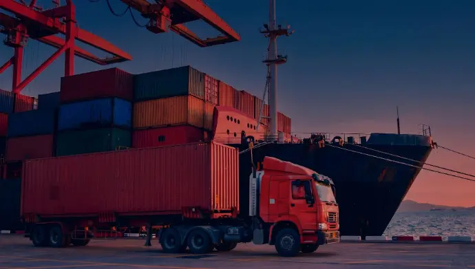 Heavy-duty truck transporting containers at an HSO logistics terminal